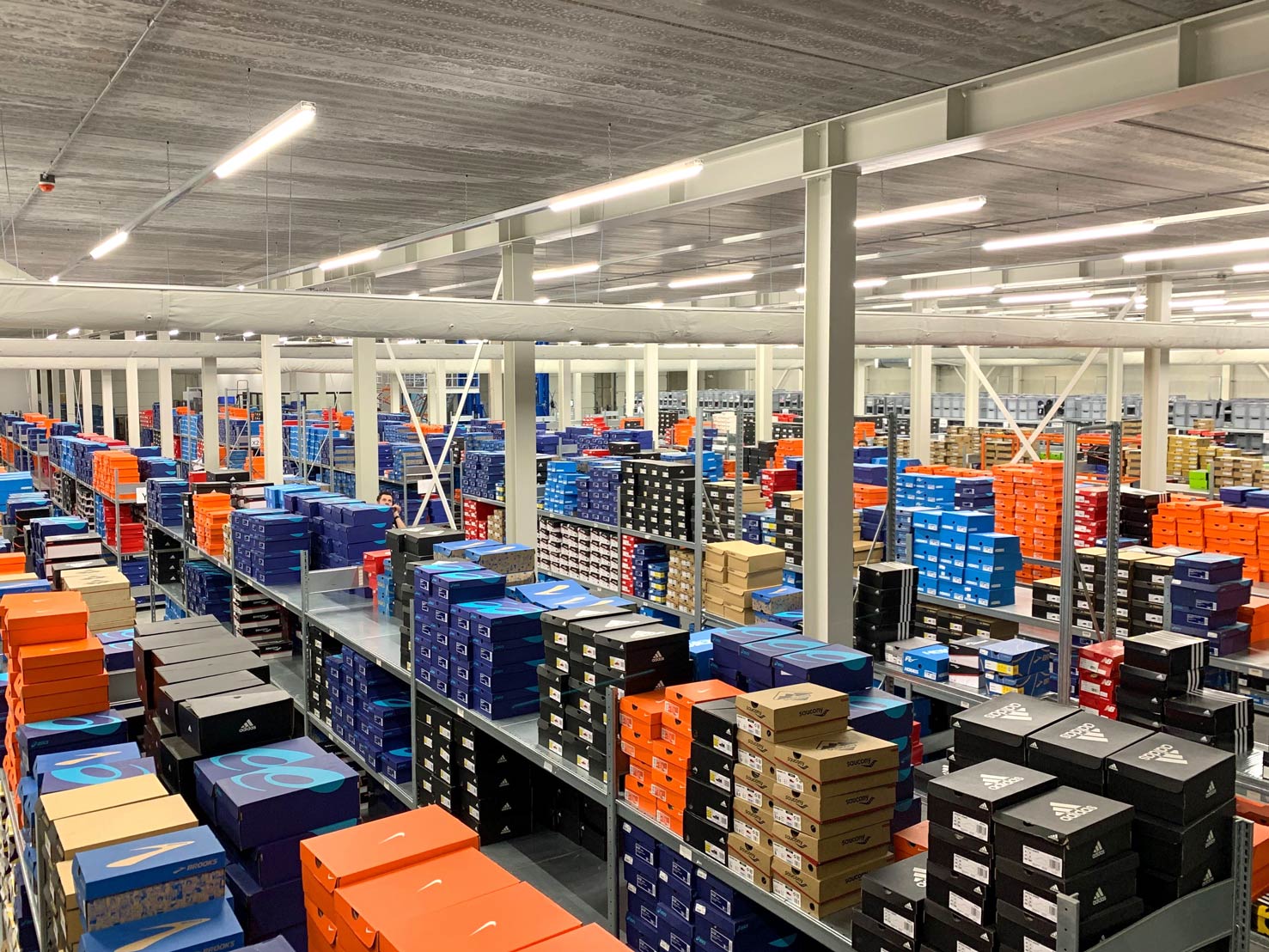 Rijen schoenendozen van verschillende hardloopmerken in het distributiecentrum van All4Running